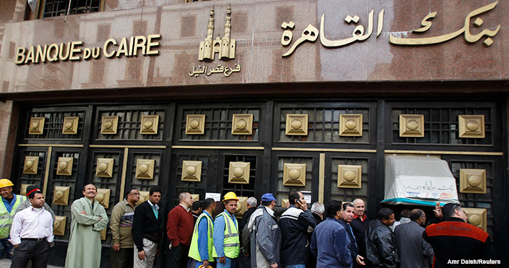 People stand in line to make withdrawals outside Cairo Bank in downtown Cairo on 6 February 2011, the first day for the country’s banks to open after a weeklong closure due to political protests.